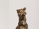 une sculpture représentant un ours assis sur une table blanche