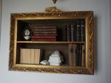 une étagère avec des livres et une horloge dessus