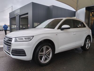 Le SUV Audi blanc est garé devant un immeuble.