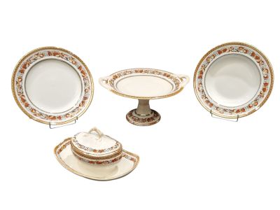 four pieces of porcelain dinnerware including a cake stand, plate, and bowl