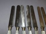 six knives are lined up in a row on a table