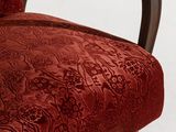 an upholstered chair with a red velvet upholstered seat