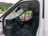 a white van with black seats and a red car in the background