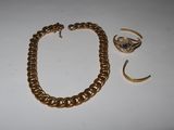 a close up of a gold bracelet and ring on a table