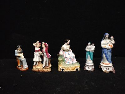 several figurines of people are posed on a black surface