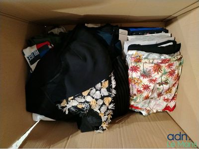 une boîte remplie de vêtements, avec un sac à l'intérieur