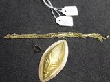a gold necklace with a leaf on it and a silver chain