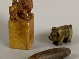 three small figurines of animals and a bear on display