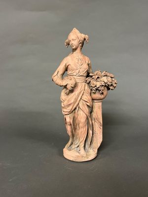 statue d'une femme tenant un panier de fleurs, posée sur un socle