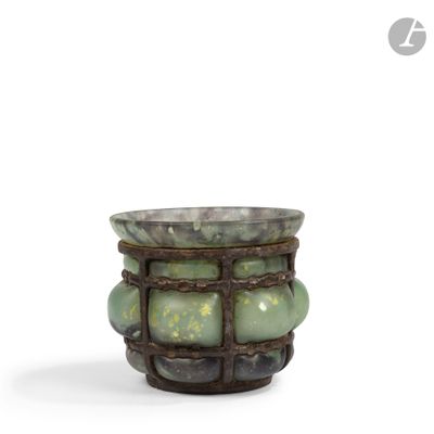 a small vase with green stones in it on a white surface
