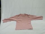 pink long sleeved shirt laying on a white background