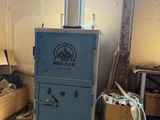 une machine bleue dans une pièce remplie de caisses en bois