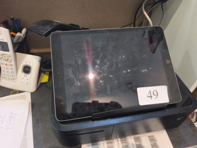 une tablette posée sur une imprimante, sur un bureau