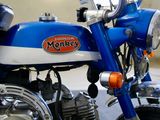 a blue and white motorcycle parked in a garage
