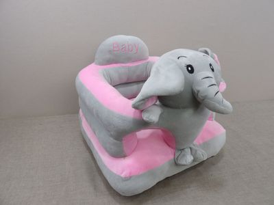 un éléphant en peluche assis sur une chaise rose et grise