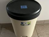 a black and white trash can sitting on a tiled floor