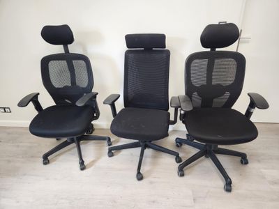 trois chaises de bureau noires posées sur un parquet en bois massif