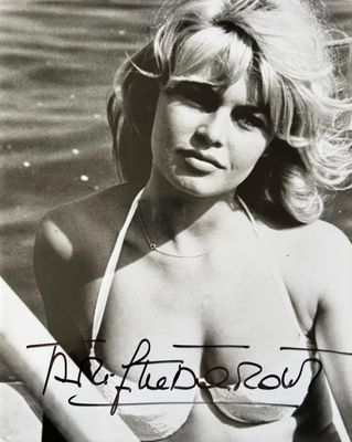 black and white photograph of a woman in a bikini sitting in a boat