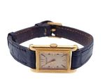 an image of a wrist watch with a gold case and blue leather strap