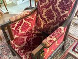 a red and gold chair in a room with a rug on the floor