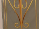 a glass display case with a gold design on it