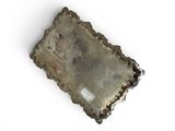 an old silver tray sitting on top of a white surface