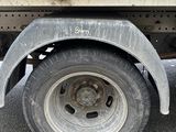 a white truck with a flat tire parked in a parking lot