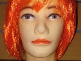 une tête de mannequin coiffée d'une perruque orange