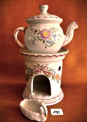 a white teapot with a spoon in it on a table
