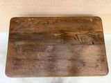 a wooden cutting board on a table on the floor