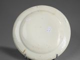 a white plate on a stand on a gray surface