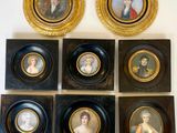 six portraits encadrés sont accrochés au mur