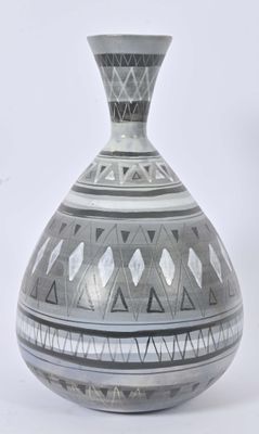a black and white vase sitting on a white surface