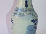 a blue and white vase sitting on a white surface