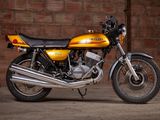 a yellow motorcycle parked in front of a brick wall