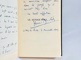 an open book with a handwritten note on it sitting on a table