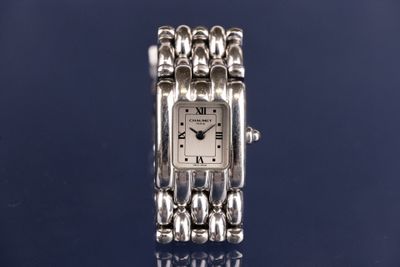 a close up of a watch on a table with a blue background