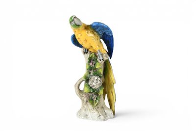 une figurine représentant un perroquet perché sur une souche d'arbre