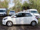a small white car that is parked in a parking lot