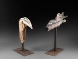 paire de têtes d'oiseaux sculptées sur des socles, sur fond noir