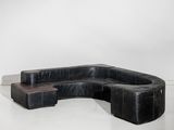 une photo d'un canapé modulable en cuir noir avec une table basse
