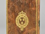 an old book with a gold emblem and a crown on it