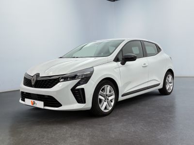 Une voiture blanche est garée dans une pièce au sol noir.