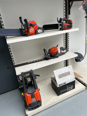 several chainsaws and chainsaws are on a shelf in a garage