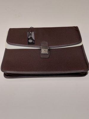 une image représentant une mallette marron et blanche posée sur une table