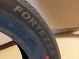 the tire of a motorcycle is sitting on the floor in front of a cardboard box