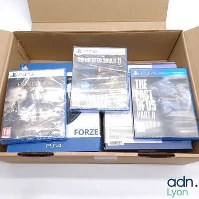 plein de jeux vidéo dans une boîte posée sur la table