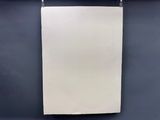 une feuille de papier blanche accrochée à un mur noir