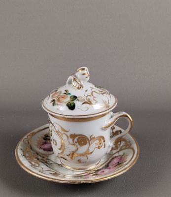 une tasse et une soucoupe posées sur une soucoupe, elle-même posée sur une autre soucoupe