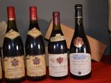 several bottles of wine are lined up on a red table